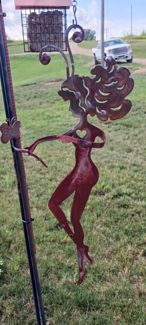 A metal sculpture of a woman with long hair.