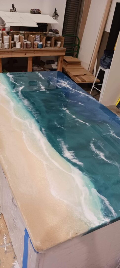 A table with a painting of the ocean on it