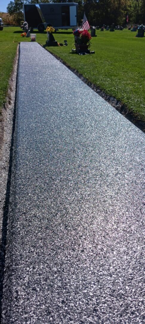 A concrete walkway with grass growing on it.