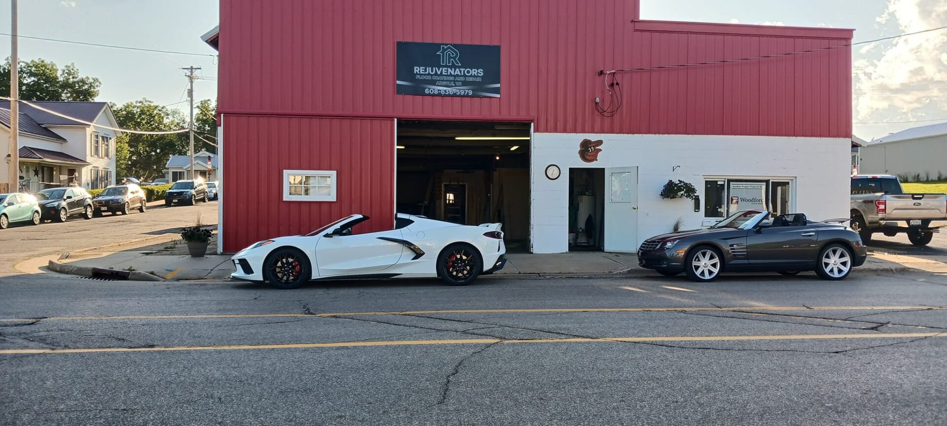 A white sports car parked in front of a red building.