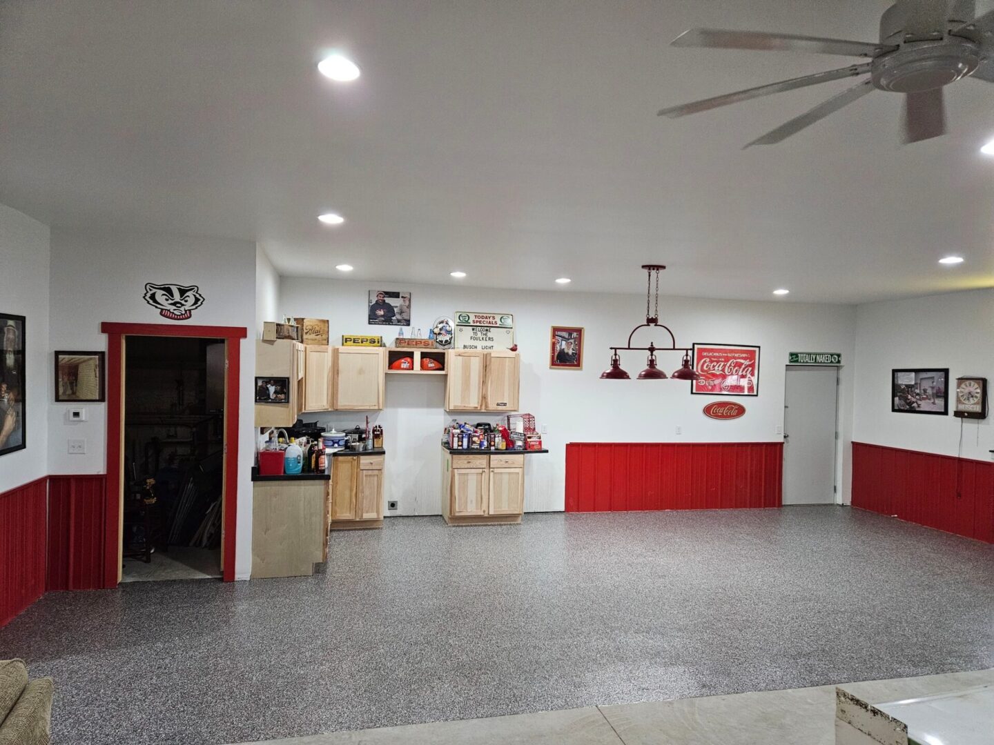 A garage with red and white walls and a ceiling fan.