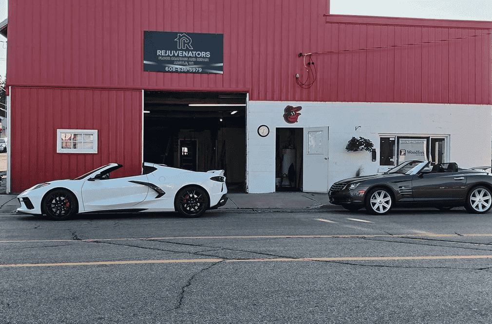 A red building with two cars parked in front of it.